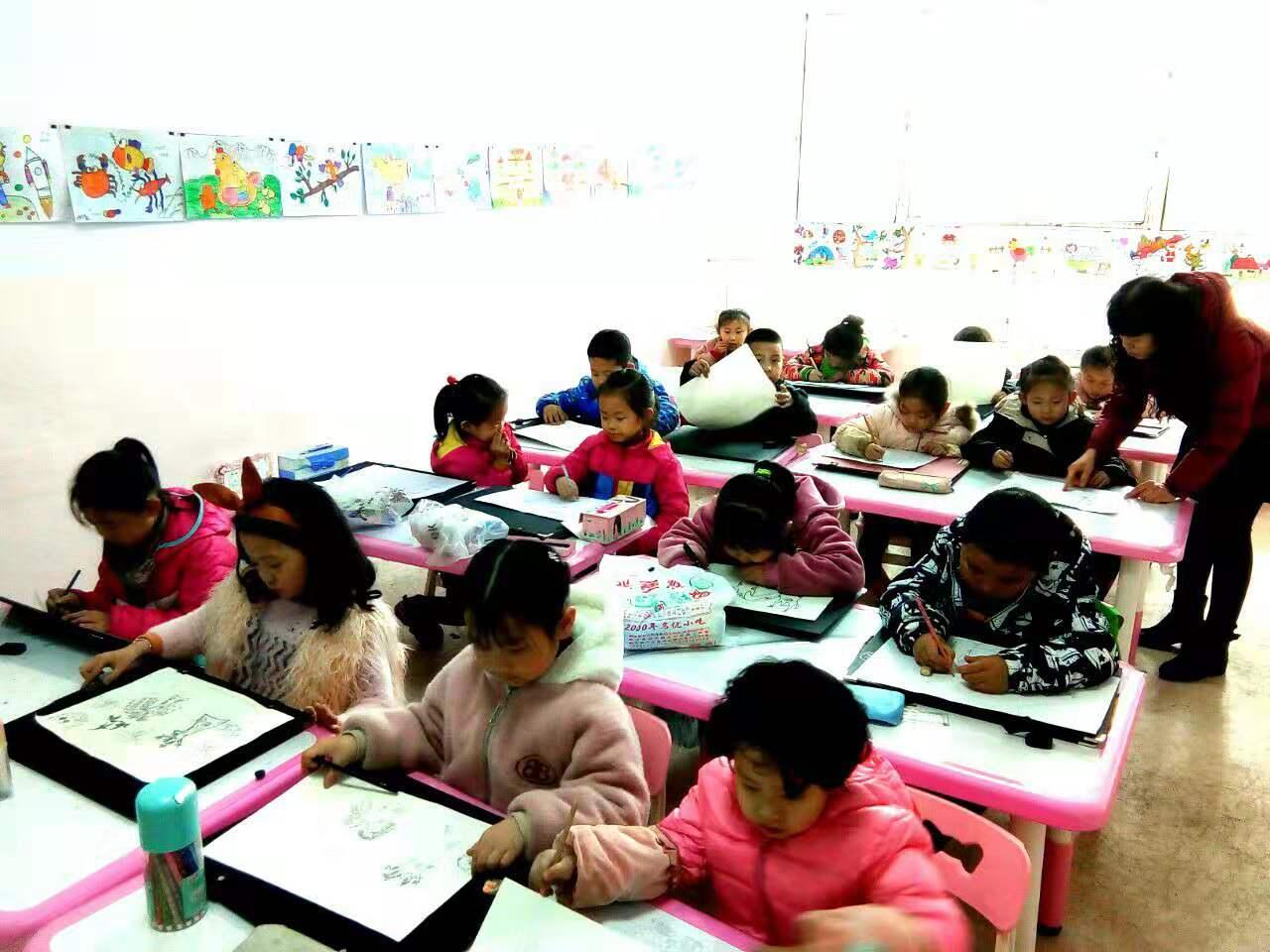 老师正在给圆梦画室一部幼小班的学生辅导作业