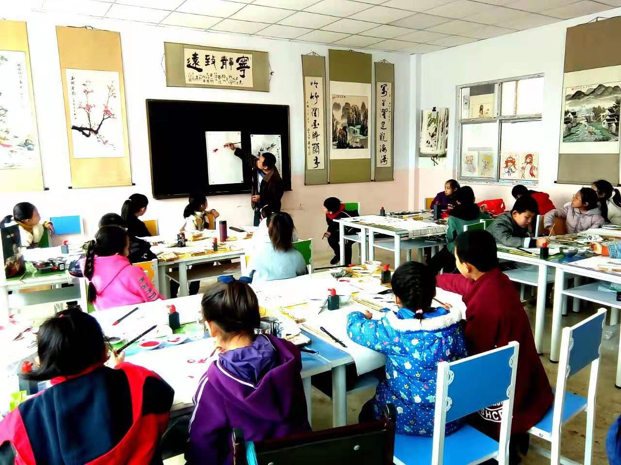 圆梦画室国画二班的学生看老师在黑板演示写意画