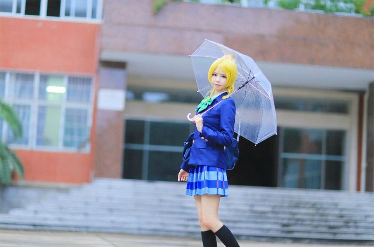 赤澤Aki扮演绚濑绘里撑着伞在教学楼门口