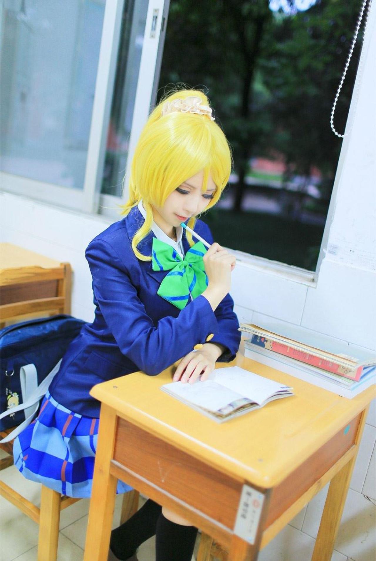赤澤Aki扮演绚濑绘拿着笔认真看着摊在课桌上的书