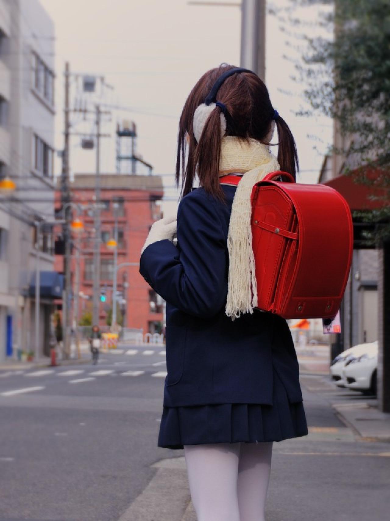 すちうる扮演萌妹，穿着蓝色校服，背着红色双肩书包，在路边等待的背影