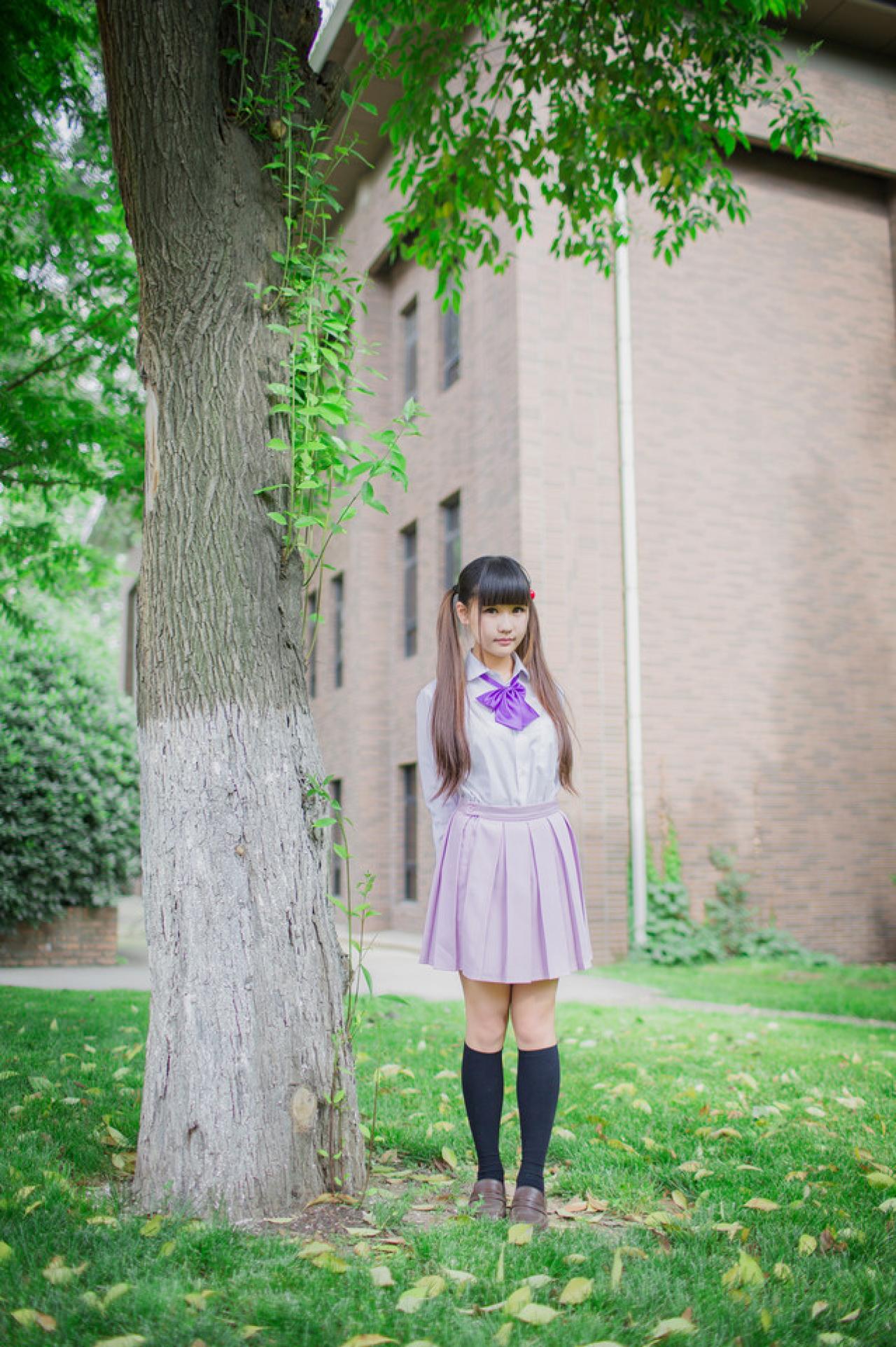 紫色制服萌妹子双手背后，站在大树旁