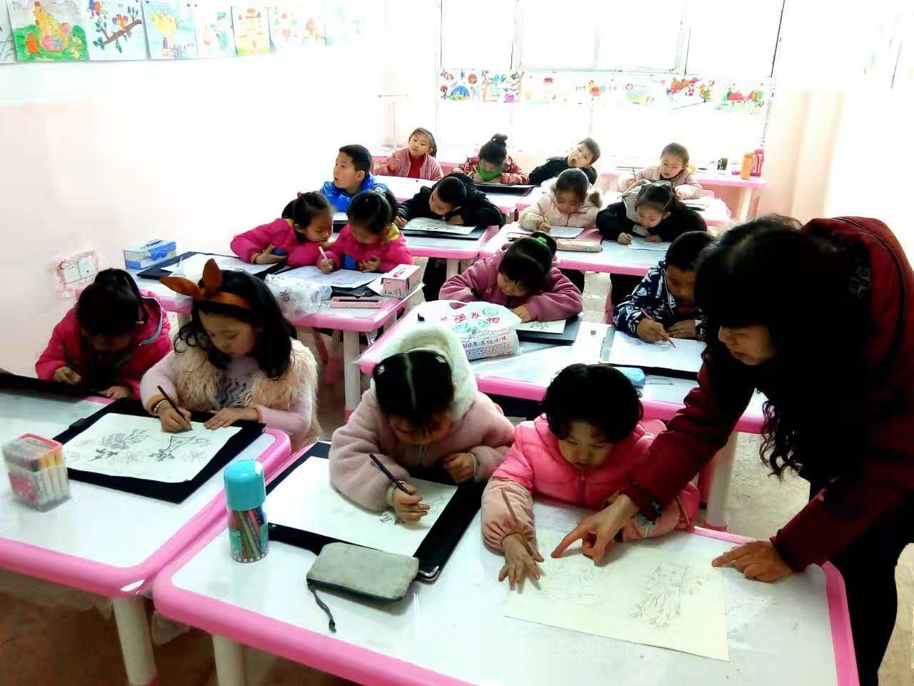 老师正在给圆梦画室一部幼小班的学生辅导作业