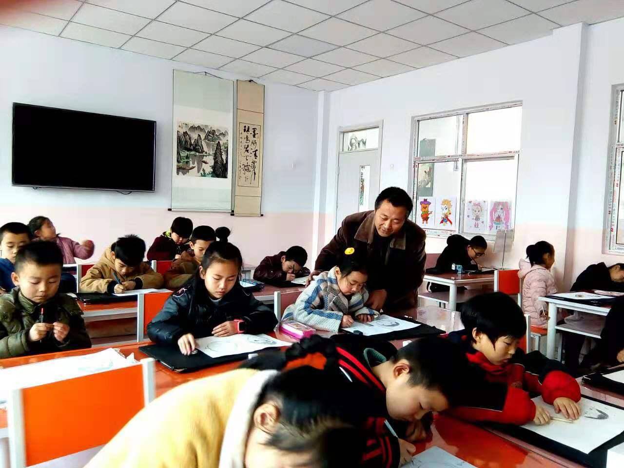 老师正在辅导一部初小班的学生课堂作业