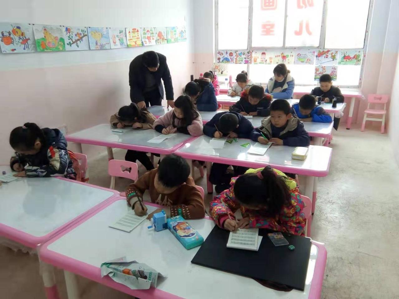 老师正在给圆梦画室硬笔书法一班的学生辅导课堂作业